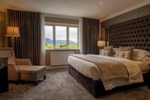 A bed or beds in a room at Killarney Oaks Hotel