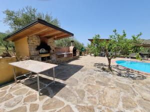 eine Steinterrasse mit Kamin neben einem Pool in der Unterkunft Villa Dei Santi, Taverna in Santa Maria di Castellabate