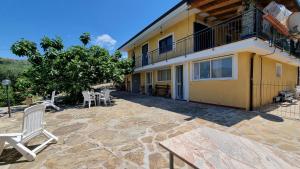 ein Haus mit einer Terrasse und Stühlen davor in der Unterkunft Villa Dei Santi, Taverna in Santa Maria di Castellabate