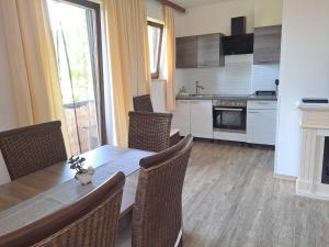 una sala da pranzo con tavolo e sedie e una cucina di Appartements Kubisko a Keutschach am See