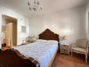 a bedroom with a large bed and a chandelier at Maison de village avec roof top in Adsubia