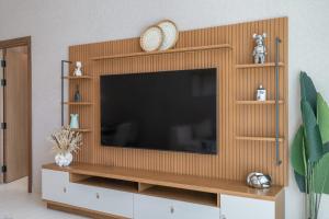 uma sala de estar com televisão numa parede de madeira em Spacious Apartment for 4 in JVC no Dubai mais 20 fotografias