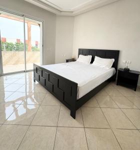 a large bed in a bedroom with a large window at Coastal serenity oasis in El Jadida