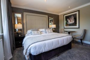 A bed or beds in a room at Killarney Oaks Hotel