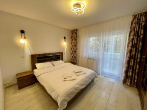 a bedroom with a large bed with two towels on it at Sea & Stay in Constanţa
