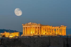 a large building with a full moon in the sky at Acropolis psiri budget rooms in Athens