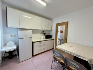 a kitchen with white cabinets and a white refrigerator at Sea & Stay in Constanţa +10 photos