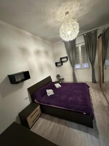 a bedroom with a purple bed and a chandelier at Cataleia in Biella