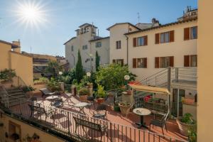 a balcony with tables and chairs and buildings at Hostel Archi Rossi in Florence