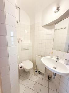 a white bathroom with a sink and a toilet at Danube Holiday Homes Studio - Top 2 in Krems an der Donau +5 photos