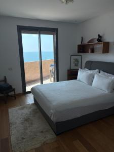 a bedroom with a bed with a view of the beach at Marina Casa Del Mar - Amazing Sea & Mosque views in Casablanca