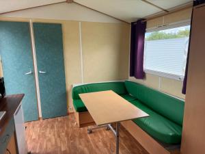 a room with a green couch and a table at Camping L'Orée des Caps in Licques +48 photos
