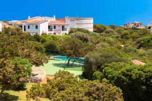 a house on a hill with a green yard at Apartamento Biniforcat in Cala en Forcat