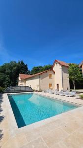 una piscina con sedie e una casa di Cottage de Montchamp a Châtenay