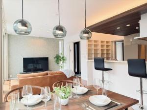 a living room with a table and a couch at Akikawa Miyoshi 7 プレミアム鉄骨 一棟貸切ヴィラ in Kumamoto