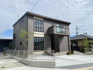 a brick building with a fence in front of it at Akikawa Miyoshi 7 プレミアム鉄骨 一棟貸切ヴィラ in Kumamoto