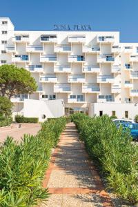 a large white building with trees in front of it at Lagrange Vacances Le Lydia Playa in Le Barcarès