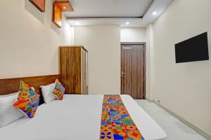 a bedroom with a bed and a tv on the wall at FabHotel Paras Palace - Bairagarh , Near Sant Hirdaram Nagar railway station in Bhopal