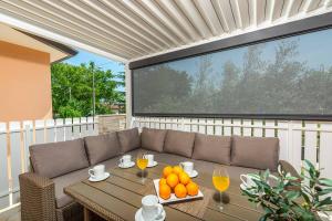 a patio with a table with oranges and wine glasses at Villa Twilight Orange in Šumber