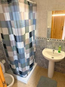 a bathroom with a sink and a shower curtain at Средиземноморская мечта in Gran Alacant +11 photos