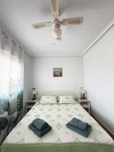 a bedroom with a bed with two blue towels on it at Средиземноморская мечта in Gran Alacant