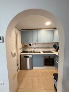 a kitchen with blue cabinets and an archway at Средиземноморская мечта in Gran Alacant