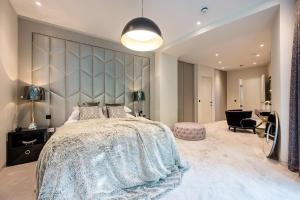 a bedroom with a large bed and a chair at Luxurious subterranean mansion - 3 spectacular bedrooms in Altrincham
