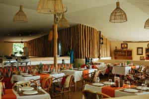 a dining room with tables and chairs and chandeliers at Lake Natron Maasai giraffe eco Lodge and camping in Mtowabaga