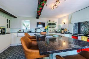 a kitchen with a table and some brown chairs at Mochdre Holiday Cottages in Mochdre +56 photos