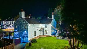 a house with blue lights on the front of it at Mochdre Holiday Cottages in Mochdre