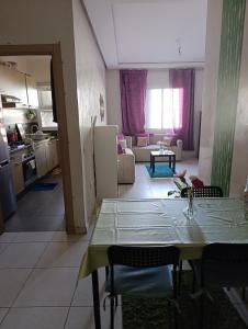 a kitchen and living room with a table and a table and chairs at Logement tout confort, équipé ! in Casablanca +2 photos