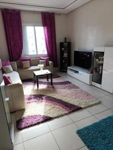 a living room with a couch and a table at Logement tout confort, équipé ! in Casablanca