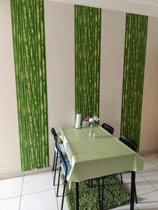 a table with chairs and a green curtain at Logement tout confort, équipé ! in Casablanca