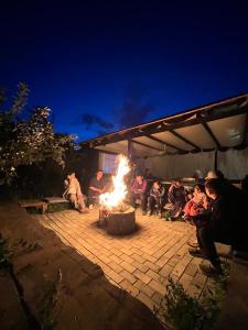 a group of people sitting around a fire in a patio at Частный сектор in Bosteri +7 photos
