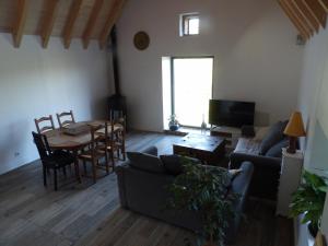 un soggiorno con un divano e un tavolo di La maison lotoise d'Alice et Jeanne a Faycelles