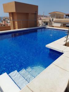 a large blue swimming pool on top of a building at Kustdroom in Villaricos