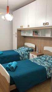 two beds with blue sheets in a room at Casa Marianna Cala Gonone mare in Cala Gonone