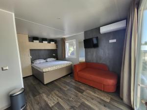 Un dormitorio con una cama y una silla roja. en DOLORES 250 meters to the beach, en Banjole