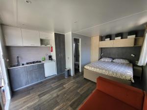 Un pequeño dormitorio con una cama y una cocina. en DOLORES 250 meters to the beach, en Banjole