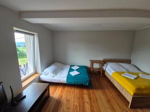 a bedroom with two beds and a window at Dom wakacyjny u Beaty nad Jeziorem Rożnowskim in Bartkowa-Posadowa