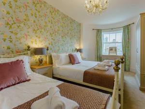 ラムズゲートにある4 Bed in Ramsgate 86741のベッド2台とシャンデリアのある寝室