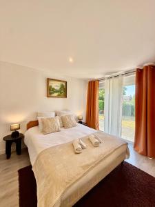 una camera da letto con un letto grande con due asciugamani sopra di Maison spacieuse avec terrasse - DABNB a Saint-Brice-sur-Vienne Altre 23 foto