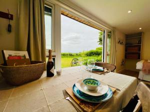 a table with a plate of food and a window at Romantic Cabin Retreat on 50-Acre Suffolk Farm in Burgh +42 photos