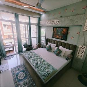 a bedroom with a large bed in a room with windows at The Roots of Jaipur Home stay in Jaipur +13 photos