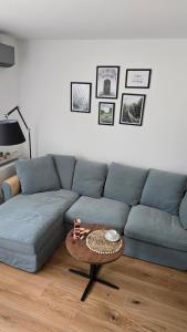 a living room with a blue couch and a table at Apartament na wydmie B9 in Łeba