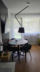 a table with chairs and a lamp in a room at Apartament na wydmie B9 in Łeba
