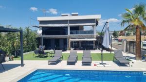 a house with a swimming pool next to a house at Agia Lydia Sea View Suite House in Karianí