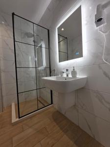 ein weißes Badezimmer mit Waschbecken und Spiegel in der Unterkunft Blue Harmony in Lalzit Bay