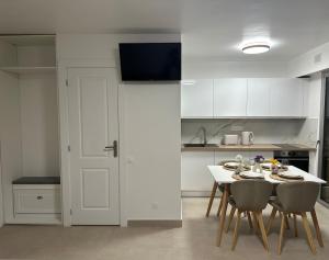 a kitchen with a table and chairs and a white kitchen at Sun, beach and relaxation in Cagnes-sur-Mer