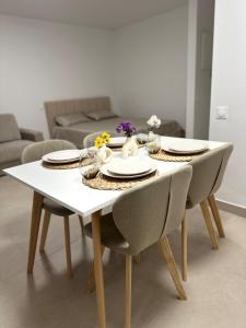 a white table with chairs and plates and flowers on it at Sun, beach and relaxation in Cagnes-sur-Mer